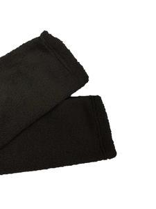 Close-up of black fuzzy plush fabric detail on a warm winter sleeve with seam stitching