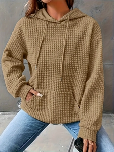 Detail of khaki waffle knit hoodie showing drawstrings and textured fabric texture