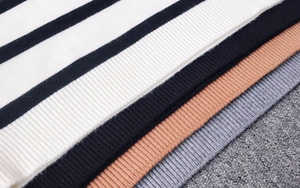 Dettaglio della trama in maglia a coste su maglioni a righe in vari colori stagionali