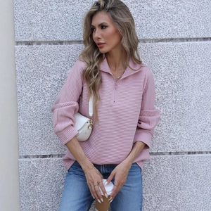Close-up of pink ribbed half-zip sweatshirt fabric and silver zipper hardware