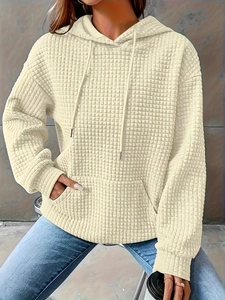 Detailed macro view of beige hooded sweatshirt with square embossed waffle texture fabric