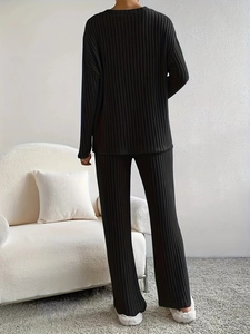 Détail de la texture côtelée verticale et du drapé fluide de cet ensemble noir en tricot