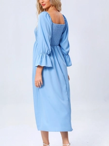 Détail de la robe bleu ciel montrant le dos smocké élégant et les poignets volantés