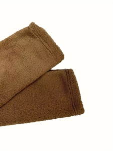 Close-up of deep brown fuzzy plush fabric with premium stitching details on the hem