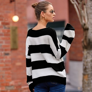 Detail view of the striped knit sweater featuring thick black and white stripes and drop shoulders