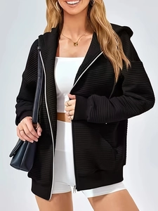 Women's black oversized zip-up hoodie with ribbed texture and functional side pockets
