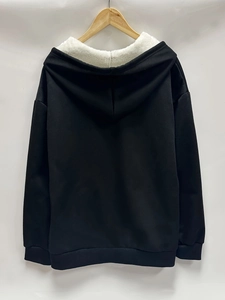 Detail showing plush white faux shearling lining inside black hooded sweatshirt back