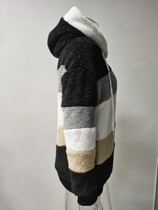 Dettaglio del morbido tessuto in pile sherpa e del design color-block sulla giacca con cappuccio