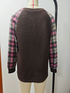 Dettaglio del busto marrone trapuntato a rombi con maniche lunghe patchwork scozzesi