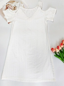 Detail of white eyelet summer dress showing the V-neck lace trim and hollow embroidery
