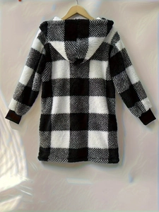 Rear view of a fuzzy black and white checkered hooded jacket on a wooden hanger