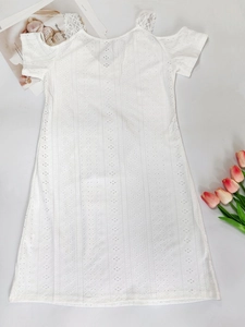 Detail of white eyelet lace dress with cold-shoulder cut and delicate embroidery