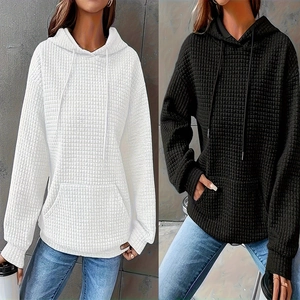Detail of waffle knit fabric on hooded sweatshirts with kangaroo pockets and drawstrings