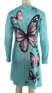 Close-up of the elegant butterfly print and watercolor pattern on a blue long-sleeve dress