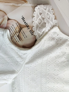 Close-up of white eyelet embroidery and intricate crochet lace on a boho summer dress