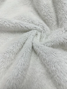 Detailed close-up showing soft white long-fiber plush fabric of a winter hooded jacket