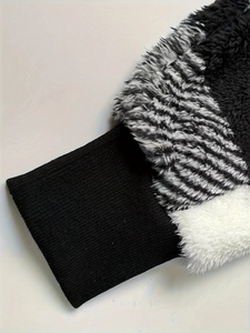 Detail of plush fleece jacket featuring black ribbed cuffs and striped faux fur texture