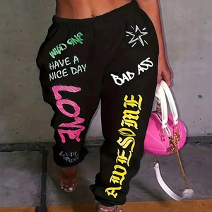 Détail du pantalon de jogging noir avec lettrage graffiti coloré et chevilles élastiques