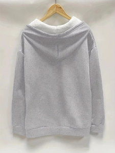 Detail view of the plush white fleece lining and grey knitted texture of the hooded jacket
