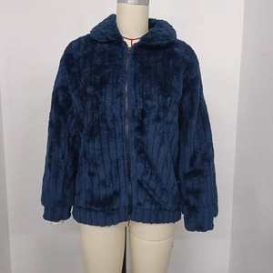 Dettaglio della giacca in pile blu scuro con polsini a costine e chiusura a zip