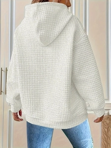 Detailed back view of white oversized hoodie showing waffle knit texture and ribbed cuffs