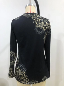 Detail of elegant black long sleeve top with yellow mandala floral print on back