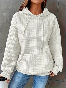 Close-up of white waffle texture hoodie with drawstring hood and kangaroo pocket