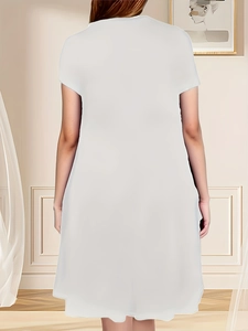 Back view of a white short-sleeve casual dress for women in a minimalist indoor setting