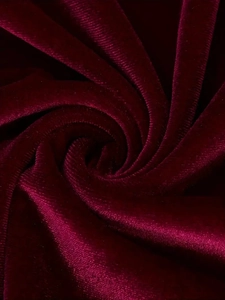 Detailed macro view of soft burgundy velvet fabric with rich texture and subtle sheen
