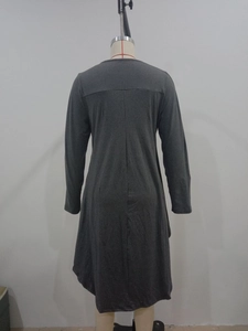 Detail view of the stitching and irregular hem on this grey long-sleeve knit dress