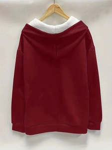 Detail view of burgundy fleece-lined hoodie with white sherpa interior on wooden hanger