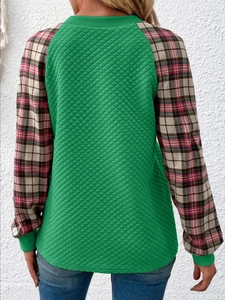 Vista posteriore di una felpa trapuntata verde a maniche lunghe con dettagli patchwork