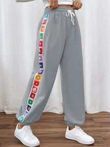 Women's gray sweatpants featuring colorful geometric floral side stripe and drawstring
