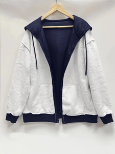 Detail of warm fleece hoodie featuring navy blue accents and white fuzzy faux shearling fabric