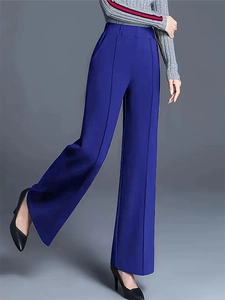 Detail of high-waist straight-leg trousers in navy blue featuring sharp vertical creases