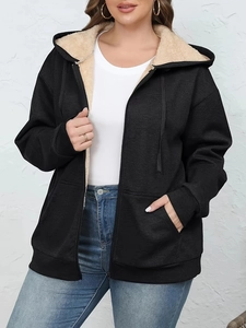 Detail view of black zip-up hoodie featuring warm beige sherpa fleece lining and hood