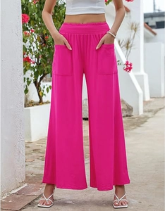 Detail of high waisted wide leg yoga pants in fuchsia with elastic waist and large side pockets