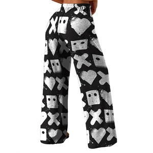Detail of high-waisted wide-leg trousers featuring white heart and geometric prints