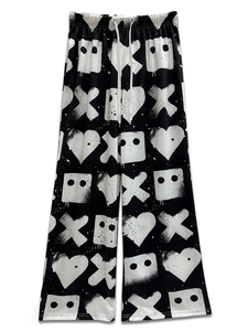 Detailed view of urban graffiti print wide leg pants with adjustable white drawstring waist
