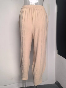 Detail of high waist elastic waistband with drawstring on textured casual cotton pants
