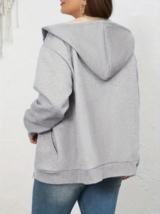 Detail of warm beige faux sherpa lining and gray knit fabric on the back of hooded jacket