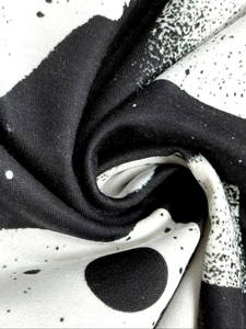 Close-up of lightweight wide-leg trousers showing soft abstract ink print fabric texture