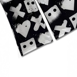 Detail view of the wide-leg pants featuring white graffiti spray paint patterns on black