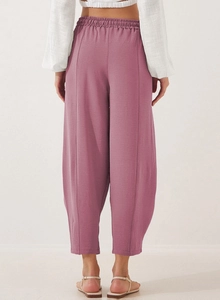 Detail of high waisted wide leg dusty pink trousers with elastic back and fabric texture