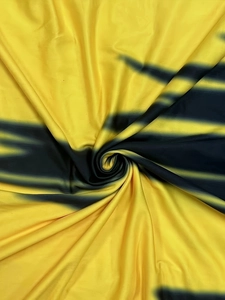 Détail du satin brillant dégradé jaune et noir avec un drapé soyeux et une texture fine