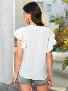 Détail du tissu à pois suisses et manches à volants double couche sur ce haut d'été blanc