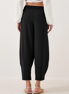 Rear view of black high-waisted cropped harem pants showing elastic waistband and fabric texture