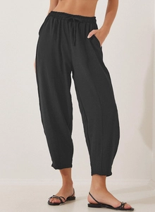 Detail view of black high waist drawstring elastic waistband and side pockets on cropped pants