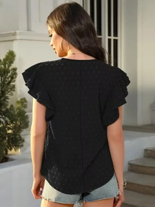 Détail de la texture à pois suisses noirs et manches à volants de ce haut d'été