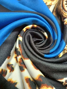 Detailed close-up of 3D leopard print fabric with royal blue and black color blocks